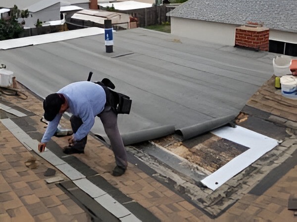 The contractor is working on the roof for repairing the roof of a building